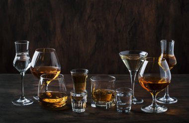 Güçlü Ruhlar Seti. Çeşitli gözlük sert alkollü içecekler: votka, konyak, tekila, brendi ve viski, grappa, likör, vermut, tentür, rom. Vintage bar sayacı arka plan, seçici odak