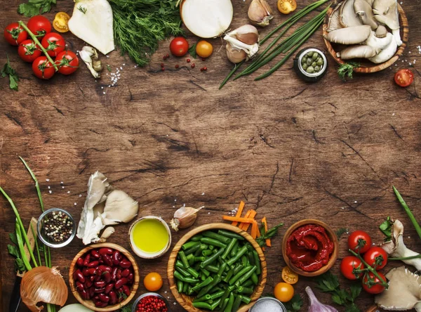 Food cooking background, ingredients for preparation vegan dishes, green bean, vegetables, roots, spices, mushrooms and herbs. Healthy vegetarian food concept. Rustic wooden table, top view, copy space