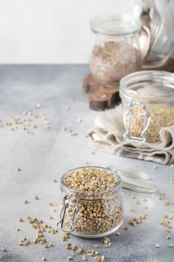 Kavanozda ham yeşil karabuğday, gri mutfak masasında sağlıklı vejetaryen gıda, kopya alanı, seçici odak