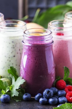 Berry meyve cokctalis, smoothies ve milkshakes, taze meyve ve çilek kahverengi masada, natürmort, seçici odak