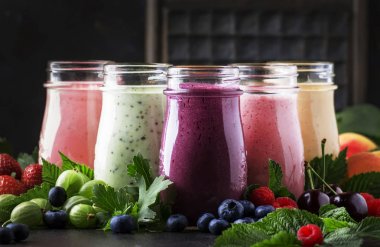Berry meyve cokctalis, smoothies ve milkshakes, taze meyve ve çilek kahverengi masada, natürmort, seçici odak