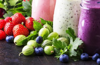 Berry meyve cokctalis, smoothies ve milkshakes, taze meyve ve çilek kahverengi masada, natürmort, seçici odak