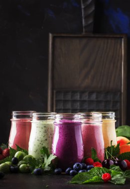 Berry meyve cokctalis, smoothies ve milkshakes, taze meyve ve çilek kahverengi masada, natürmort, seçici odak