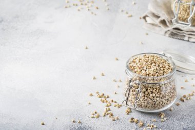 Kavanozda ham yeşil karabuğday, gri mutfak masasında sağlıklı vejetaryen gıda, kopya alanı, seçici odak