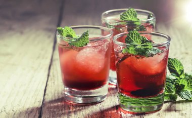 Beyaz rom, kırmızı vermut, nane ve buz küpleri, ahşap masa, seçici odak ile Alkollü kokteyl