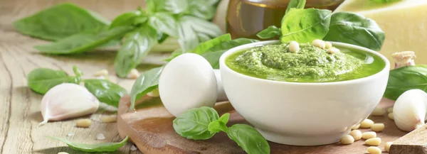 Italian Pesto sauce with green basil, garlic, parmesan cheese, cedar nuts and olive oil, in mortar with pestle, selective focus