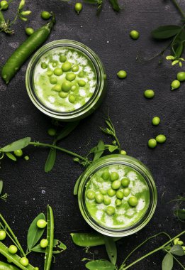 Gri mutfak masasında cam kavanozda Krem yeşil bezelye çorbası, kopya alanı, seçici odak