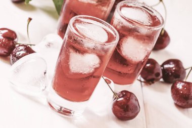 Icherry suyu, beyaz masa, tonda, seçici odak ile buz kırmızısı içecek