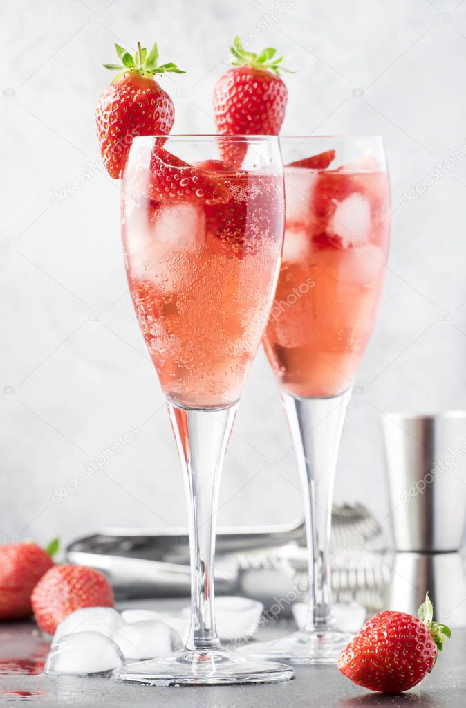 Rossini alcoholic cocktail with Italian sparkling wine, strawberry puree and ice in champagne glasses, place for text, selective focus