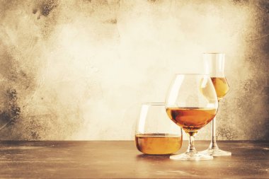 Çeşitli sert güçlü alkollü içecekler ve alkollü içkiler seçimi: konyak, brendi ve rom. Gri çubuk sayacı arka planı, seçici odaklama, kopyalama alanı