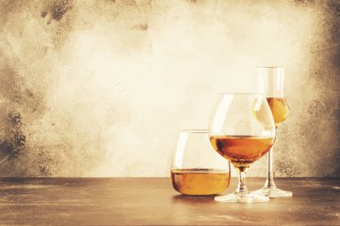 Selection of hard strong alcoholic drinks and spirits in assortment: cognac, brandy and rum. Gray bar counter background, selective focus, copy space clipart