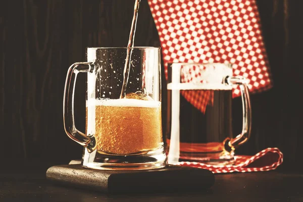 ドイツの軽いビール二杯 マグカップ バーカウンターでは 暗いに注がれるビール セレクティブ フォーカス — ストック写真