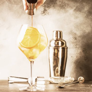 Aperol spritz kokteyl hazırlanması, barmen acı dökülen Devol, yaz İtalyan düşük alkol soğuk içecek, siyah bar counter arka plan, yaz ruh kavramı. Seçici odak