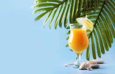 Mango suyu, rom, likör, limon ve buz, mavi arka plan, fotokopi alanı