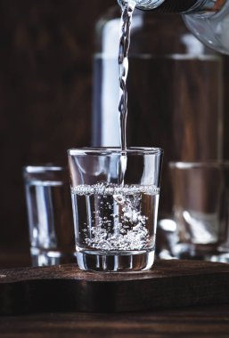 Aguardiente-geleneksel Ispanyol güçlü alkollü içecek, üzüm Moonshine veya votka, eski bir ahşap masada gözlük, metin için yer