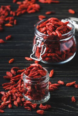 Goji meyveleri cam kavanoz, koyu ahşap masa, seçici odak