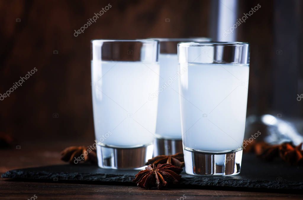 Ouzo - Greek anise brandy, traditional strong alcoholic drink in glasses on the old wooden table, place for text