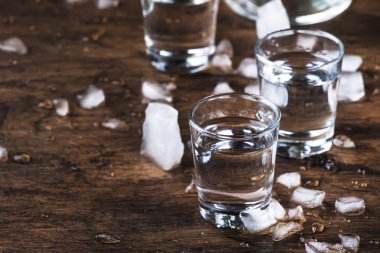 Aguardiente-geleneksel Ispanyol güçlü alkollü içecek, üzüm Moonshine veya votka, eski bir ahşap masada gözlük, metin için yer