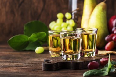 Rakija, rakı veya Rakia-fermente meyve dayalı Balkan güçlü alkollü içecek Brandy tipi, Vintage ahşap masa, rustik tarzda hala yaşam, metin için yer