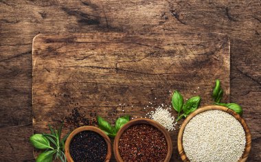 Quinoa seti. Kasesiyah, beyaz ve kırmızı ham Quinoa taneleri, groats çeşitli, ahşap rustik mutfak masası, üst görünüm ve kopyalama alanı