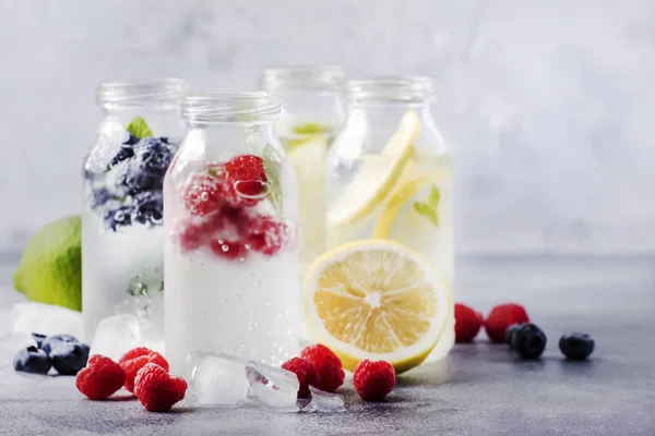 Summer drinks set. Berry, fruit and citrus non-alcoholic refreshing ice cold beverages and cocktails in glass bottles on white background