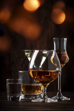 Güçlü Ruhlar Seti. Çeşitli gözlük sert alkollü içecekler: votka, konyak, tekila, brendi ve viski, grappa, likör, vermut, tentür, rom. Vintage bar sayacı arka plan, seçici odak