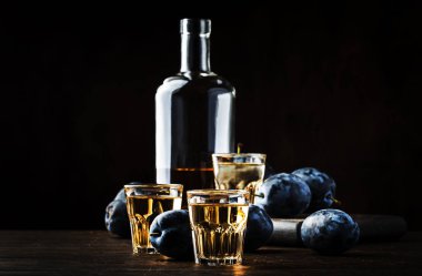 Slivovica - erik brendi veya erik votka, sert likör, eski ahşap masa, taze erik, kopya alanı gözlük güçlü içki