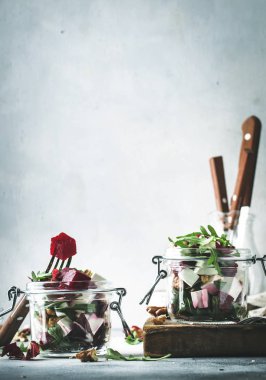 Pancar ve peynir sağlıklı salata arugula ve ceviz, trendy salata kavanozu, gri mutfak masası, metin için yer, seçici odak