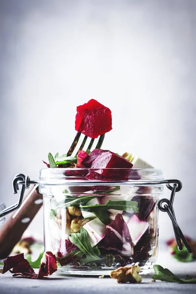 Beet and cheese healthy salad with arugula and walnuts, trendy salad jar, gray kitchen table, place for text, selective focus — Stock Image Beet Cheese Healthy Salad Arugula Walnuts Trendy Salad Jar Gray Royalty Free Stock Images