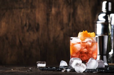 Kırmızı vermut ile Americano Alkol kokteyl, acı, soda, portakal lezzet ve buz, koyu ahşap bar sayacı arka plan, bar araçları, seçici odak
