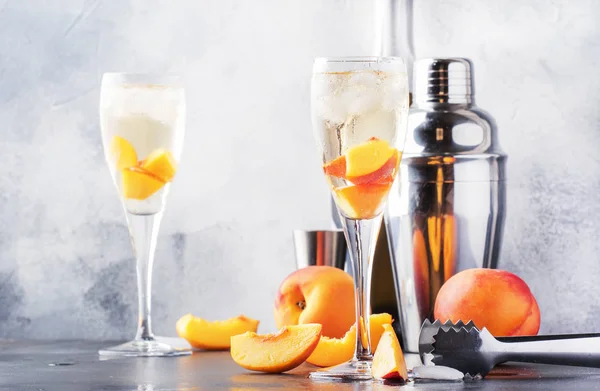 ベリーニ スパークリングワイン 砂糖シロップ レモンジュース 桃と氷 灰色のテーブルの背景 コピースペースとアルコールカクテル — ストック写真