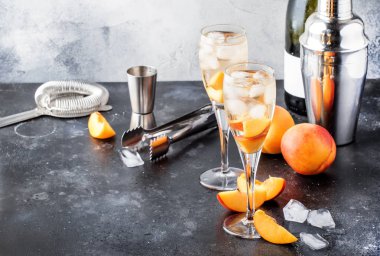 Bellini, köpüklü şarap, şeker şurubu, limon suyu, şeftali ve buz, gri masa arka plan, kopya alanı ile alkollü kokteyl
