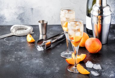 Bellini, alcoholic cocktail with sparkling wine, sugar syrup, lemon juice, peach and ice, gray table background, copy space clipart