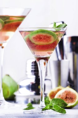 Bar araçları ile gri masada shot cam pembe incir martini kokteyl, seçici odak