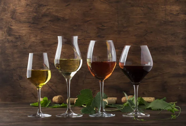 Wine set. Red, white and rose wine in assortment in wineglasses. Wine tasting, vintage wooden background, selective focus, copy space