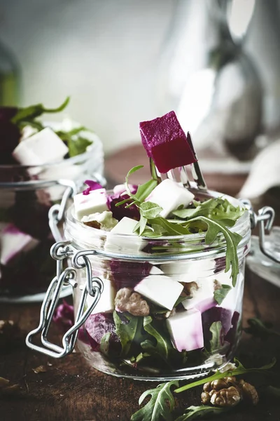 Beet and cheese healthy salad with arugula and walnuts, trendy salad jar, gray kitchen table, place for text, selective focus — Stock Image Beet Cheese Healthy Salad Arugula Walnuts Trendy Salad Jar Gray Stock Picture