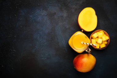 Mavi arka plan üzerinde taze meyve ile cam kavanozda Mango yüzlü, kopya alanı, üst görünümü