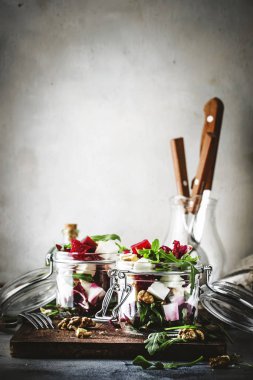 Pancar ve peynir sağlıklı salata arugula ve ceviz, trendy salata kavanozu, gri mutfak masası, metin için yer, seçici odak