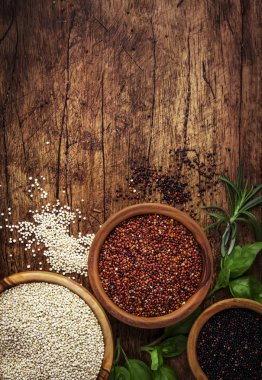 Quinoa seti. Kasesiyah, beyaz ve kırmızı ham Quinoa taneleri, groats çeşitli, ahşap rustik mutfak masası, üst görünüm ve kopyalama alanı