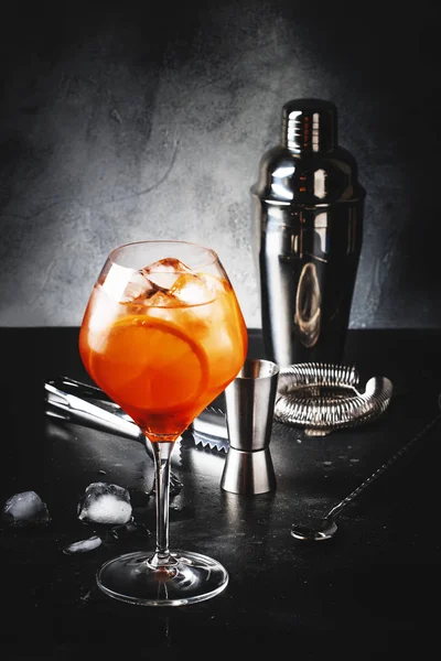 Aperol Spritz 鸡尾酒在大酒杯中 配橙和冰 夏季酒精冷饮 深色酒吧柜台 带钢筋工具 复制空间 — 图库照片