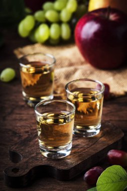 Rakija, rakı veya rakı - Balkan sert alkollü içecek veya fermente meyve brendi, eski ahşap masa, natürmort, kopya alanı