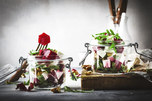 Beet and cheese healthy salad with arugula and walnuts, trendy salad jar, gray kitchen table, place for text, selective focus — Stock Image Beet Cheese Healthy Salad Arugula Walnuts Trendy Salad Jar Gray Royalty Free Stock Photos