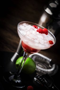 Ahududu daiquiri, beyaz rom, limon suyu, ahududu ve uzun cam ezilmiş buz ile alkollü kokteyl, çelik bar araçları ile ahşap bar sayacı