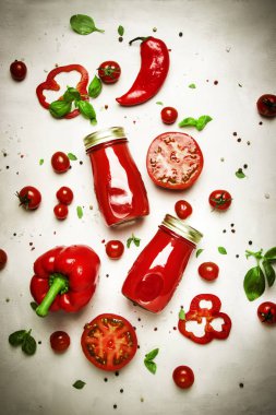 Baharatlı domates smoothies veya biber, tuz ve yeşil fesleğen beyaz arka plan üzerinde cam şişeler ile suyu, üst görünümü