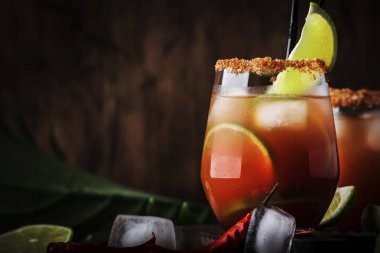 Michelada - Bira, limon suyu, domates suyu, baharatlı sos ve baharatlar, vintage ahşap arka plan, seçici odak ile Meksika alkollü kokteyl