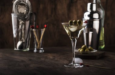 Martini votka kokteyl, kuru vermut, votka ve yeşil zeytin, bar araçları, vintage ahşap sayaç, seçici odak ile