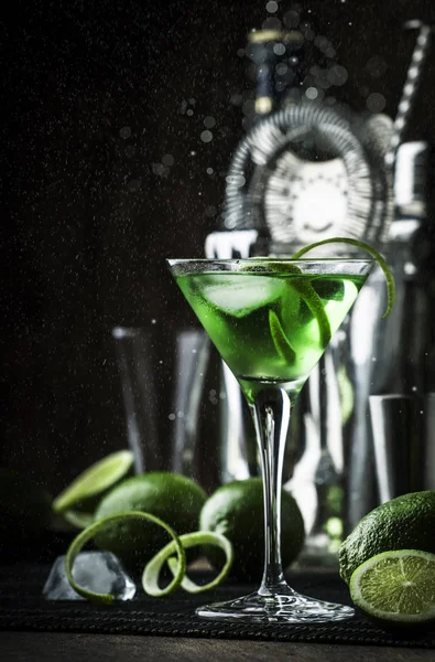 ドライジン バーマス ライムゼストと氷 バーツール 暗い背景を持つ緑のアルコールカクテルモンク — ストック写真