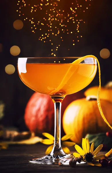 Satans whiskers, halloween cocktail with gin, vermouth, orange juice and liquor, vintage dark wooden background with festive decor