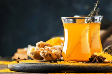 Tahta tepside cam bardakta bal bulunan sağlıklı vegan zerdeçal altın çayı. Şifalı baharatlı çay. 