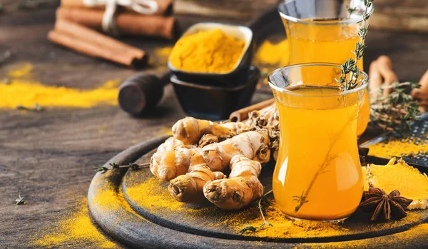 Tahta tepside cam bardakta bal bulunan sağlıklı vegan zerdeçal altın çayı. Şifalı baharatlı çay. 